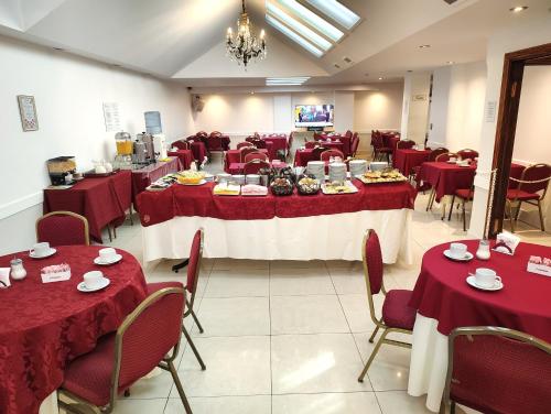 un salón de banquetes con mesas y sillas con mantel rojo en Hotel Guerrero, en Mar del Plata