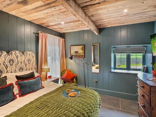 a bedroom with a bed and a wooden ceiling at Buttercup Cottage in Treborough