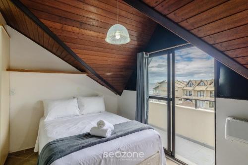 a bedroom with a bed and a large window at Casas em condomínio a Beira-Mar com piscina, Itajubá - MCSs in Itajubá