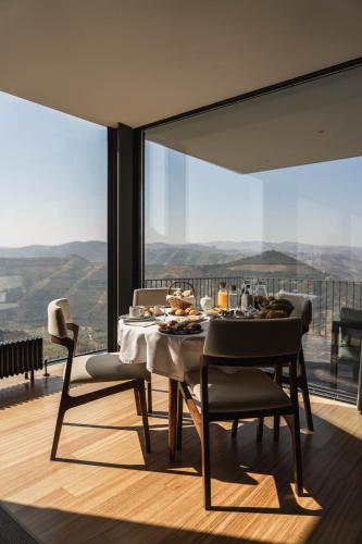 a dining room with a table and chairs with a view at Quinta Vale das Papas in Casal de Loivos