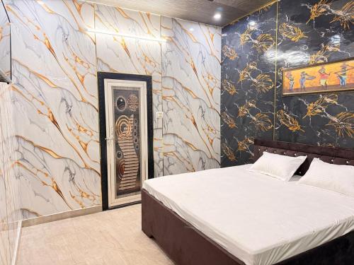 1 dormitorio con 1 cama y un mural en la pared en Hotel Tirupati Lawn, en Lucknow