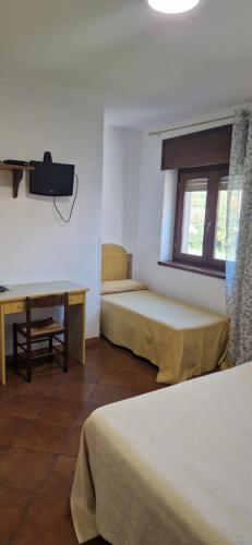 Habitación con 2 camas, escritorio y ventana. en A Casa Di Luca, en Diamante