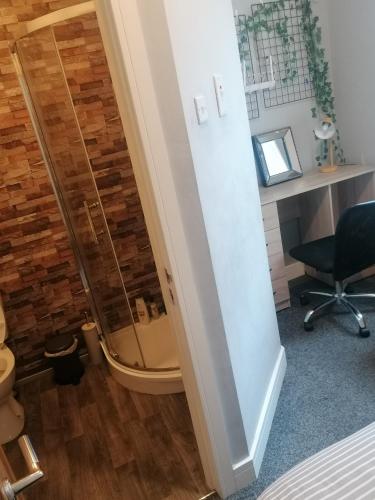 a mirror in a room with a desk and a chair at Conway Home of Relaxations in Stoke on Trent