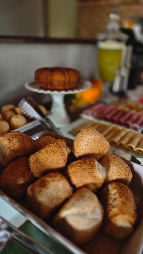 un montón de panes y pasteles en una mesa en Pousada Manga Rosa, en Chapada dos Guimarães
