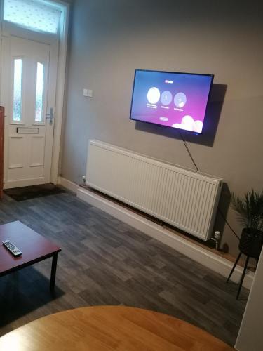 a living room with a flat screen tv on a wall at Conway Home of Relaxations in Stoke on Trent