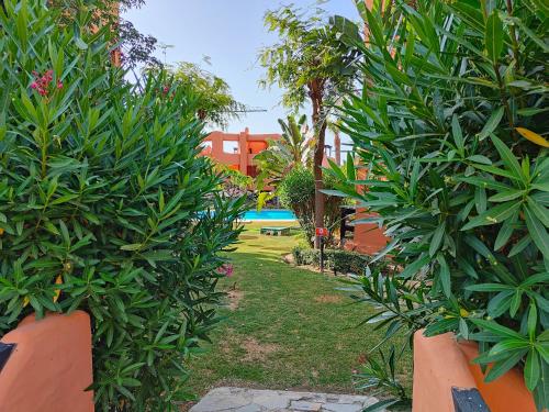 a garden with trees and a pool in the background at Ático de lujo con vistas al mar in Estepona