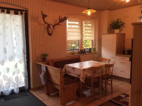 une cuisine avec une table en bois et une fenêtre dans l'établissement Ferienwohnung In Neustrelitz Mit Garten Und Grill, à Neustrelitz