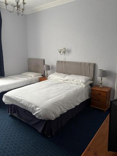 a bedroom with two beds and two night stands at ashwood hotel in Preston
