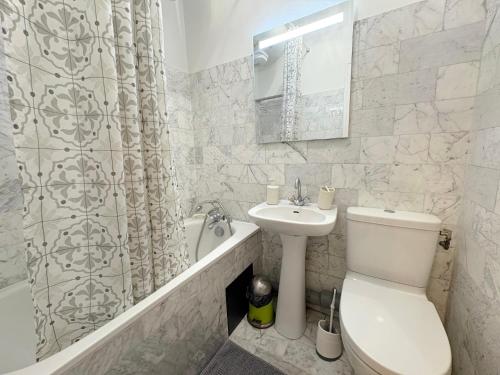 een badkamer met een toilet, een wastafel en een douche bij le studio Rennequin in Parijs