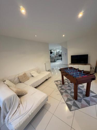 a living room with a couch and a table at Maison moderne 5 personnes, proche Lyon in Marcy-lʼÉtoile