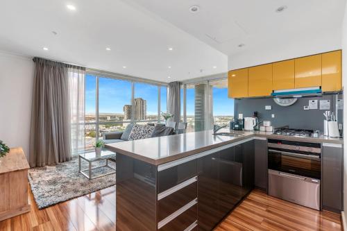 an open kitchen with a view of a living room at Adelaide Central Skyline Panoramic Suite Two in Adelaide