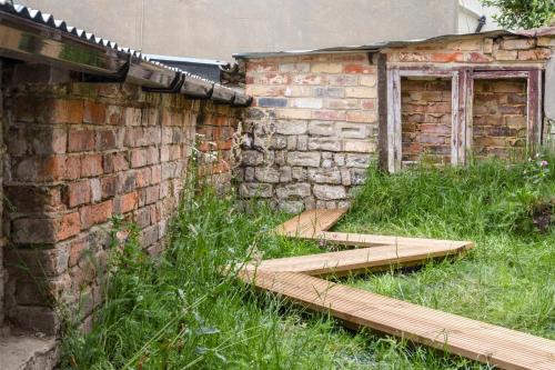 ein altes Gebäude mit Holzstufen neben einer Backsteinmauer in der Unterkunft Modern Chatham home with garden retreat in Chatham
