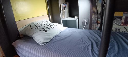 Chambre Privée Familiale 13m2 dans F2 partagé 30m2 في لو كرملين-بيستر: سرير مع وسادة بيضاء عليها كلمة مذنب