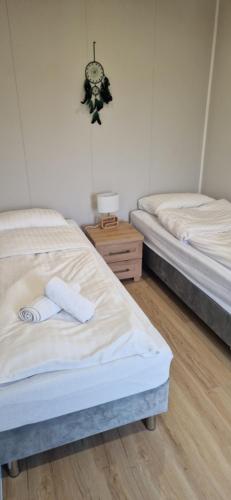 two twin beds in a room with a clock on the wall at Biały Fortepian in Koło