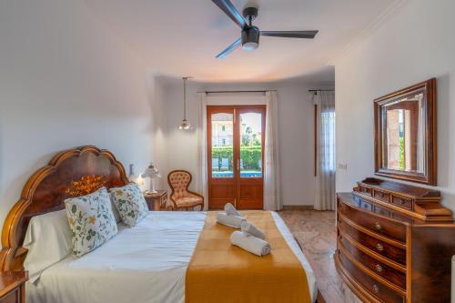 una camera con un grande letto con un comò e un comò di Villa Damar a Can Picafort