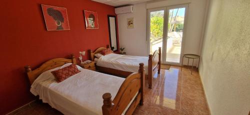 une chambre avec deux lits et une fenêtre dans l'établissement Casa Gran Mirador - Ruime vakantie villa met groot privé zwembad 8-14 pers, à Alicante