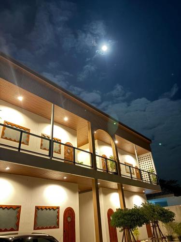a building with a balcony with the moon in the sky at สุขใจ โฮม Minimal Apartment ใกล้ Central นครปฐม แอร์เย็นฉ่ำๆ in Nakhon Pathom
