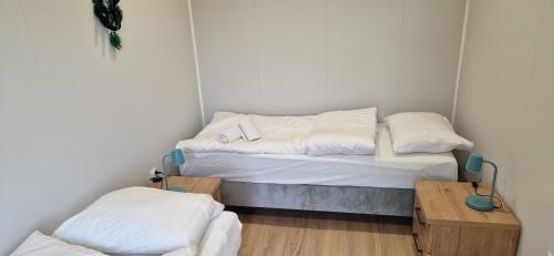 a small room with two beds and a wooden table at Biały Fortepian in Koło