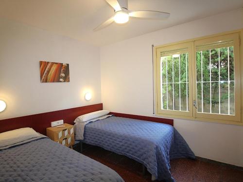 ein Schlafzimmer mit zwei Betten und einem Fenster in der Unterkunft Casa amplia con jardín a 100m de la playa de La Farella, cerca del puerto de Llançà - ES-228-168 in Llança