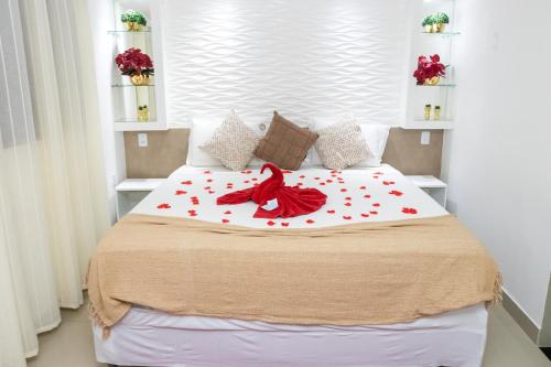 a bedroom with a bed with a red bird on it at Pousada Villa Goyá in São José da Coroa Grande