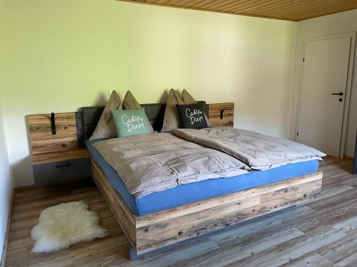 ein Schlafzimmer mit einem Holzbett mit Kissen darauf in der Unterkunft Wohnung am Attersee in Steinbach am Attersee