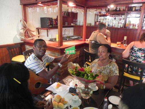 a group of people sitting at a table in a restaurant at Pousada Tropicalia in Itaparica Town