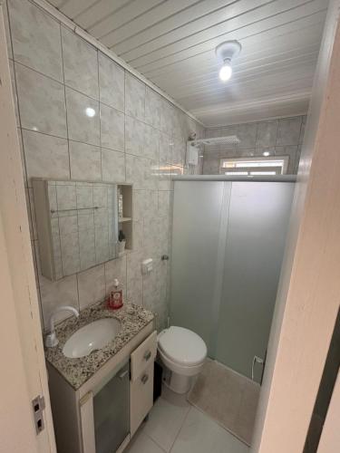 a bathroom with a toilet and a sink at Casa na Beira Mar Continental in Florianópolis