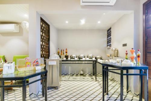 a kitchen with two blue tables in a room at Bluestone Prime by The Cosy Hotels in New Delhi