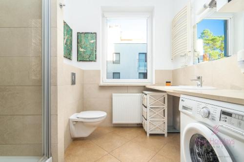 ein Badezimmer mit Toilette, Waschbecken und Waschmaschine in der Unterkunft Your Holidays Aquamarina in Misdroy