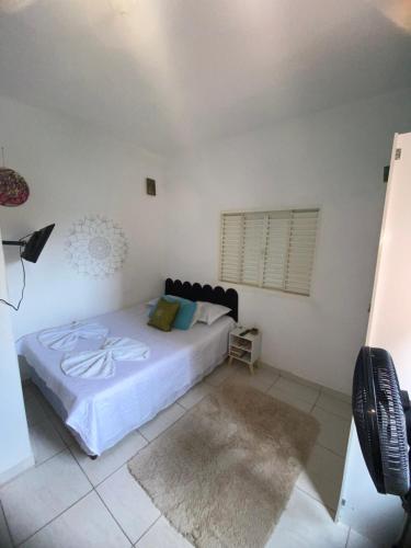 ein Schlafzimmer mit einem Bett mit weißen Laken und einem Fenster in der Unterkunft Sunset loft in São Thomé das Letras