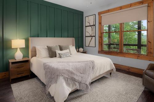 Schlafzimmer mit einem Bett mit grünen Wänden und einem Fenster in der Unterkunft Morning Glow - Luxury Mountain Cabin in Blue Ridge in Ballew Mill