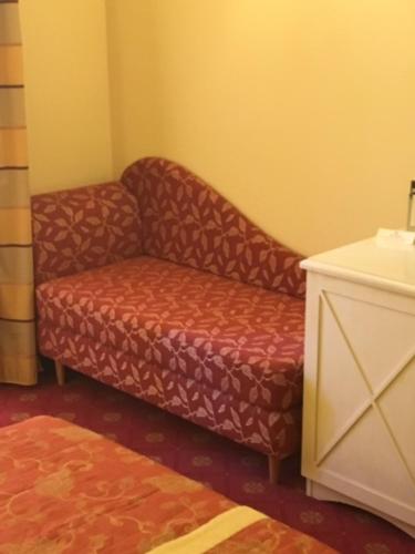 a chair and a couch in a room at Hotel Villa Cappugi in Pistoia