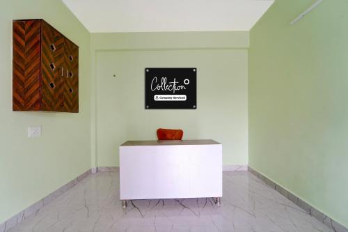 Un armario blanco en una habitación con un letrero en la pared. en Collection O MKU Madurai Formerly Mpl Elite, en Samayanallūr