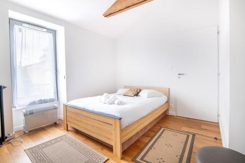 ein Schlafzimmer mit einem Bett in einem Zimmer mit einem Fenster in der Unterkunft Maison du Château, spacieuse et charmante près du PuyDuFou in Mortagne-sur-Sèvre