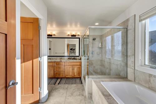 a bathroom with a shower and a tub and a sink at Windriver Hideaway - Private Hot Tub in Wolf Creek Village
