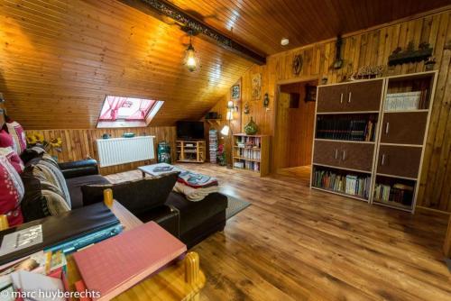 Una sala de estar con un sofá y una estantería. en Das Gîte Fleuri Mit Einer Herrlichen Aussicht, en Hazelbourg
