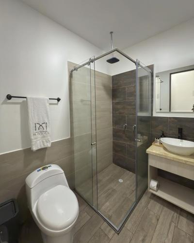 a bathroom with a shower and a toilet and a sink at M A Hotel in Popayan