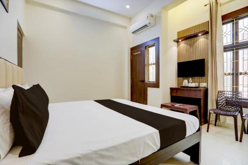 a bedroom with a bed and a desk and a television at Hotel O Sri in Banāras Cantonment