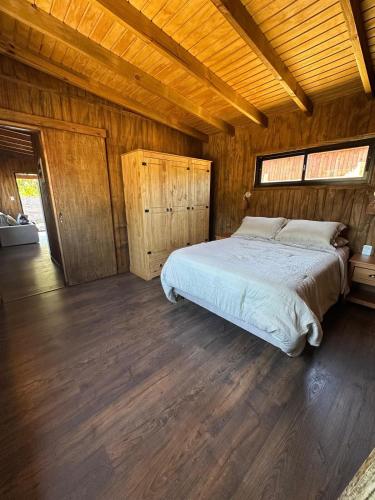 ein Schlafzimmer mit einem Bett in einem Holzzimmer in der Unterkunft Santosha in La Paloma