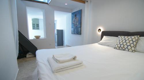 una camera da letto con un letto bianco con asciugamani sopra di Casa Bianca a Skopelos Town