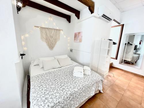 a white bedroom with a bed with white sheets at Charming Andalusian Loft in Vejer de la Frontera