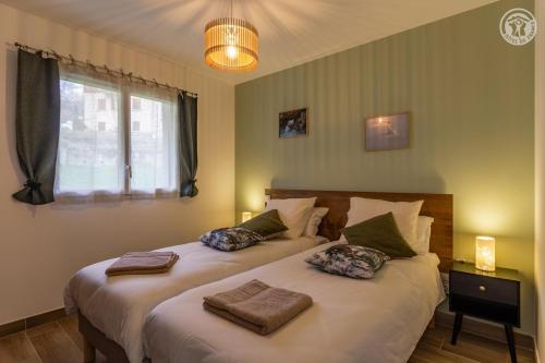 a bedroom with two beds with towels on them at Coeur de fournache in Saint-Jean-de-Maurienne