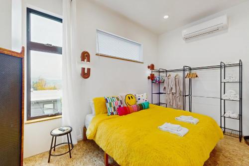 a bedroom with a bed with a yellow blanket at The HUB in Eugene