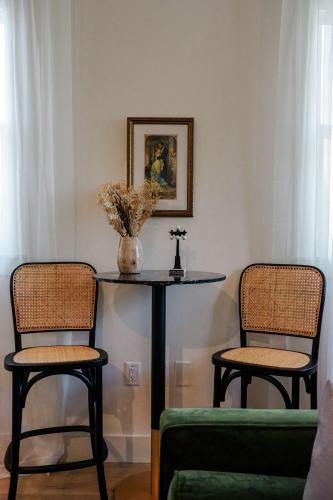a table with two chairs and a table with a vase on it at Casa Julieta - Stunning Ybor Studio in Tampa