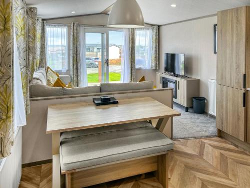 una sala de estar con una mesa y un sofá en Skokholm, en Walton West