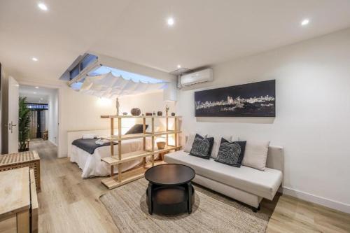 un salon avec un lit et un canapé blanc dans l'établissement ARCO Gran Via Boutique Apartments, à Madrid