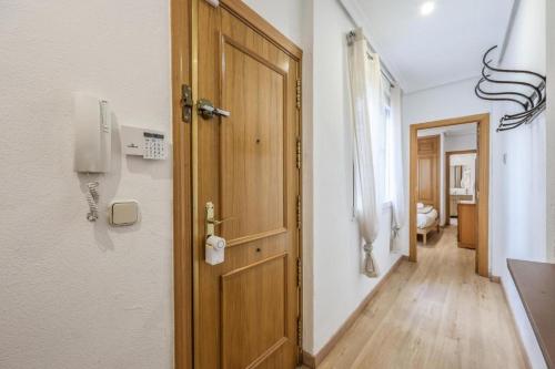 un couloir avec une porte et un téléphone sur un mur dans l'établissement ARCO Gran Via Boutique Apartments, à Madrid