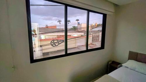 a window in a bedroom with a view of a balcony at Linda casa em Garanhuns-PE in Garanhuns