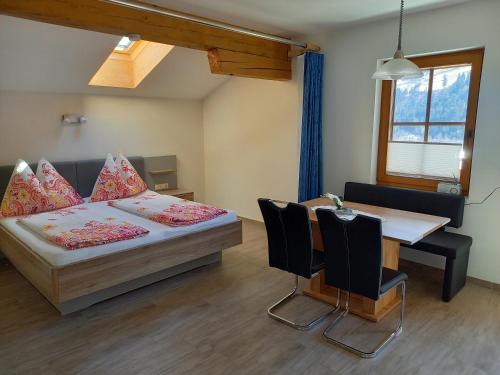 a bedroom with a bed and a table with chairs at Nagelehof 3 in Ainet