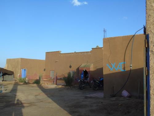 una motocicleta estacionada frente a un edificio en Kasbah Dar Lgamra, en Merzouga